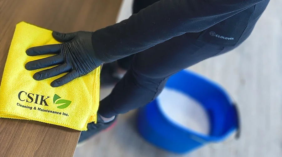 CSIK cleaner sanitizing a wooden counter with a microfiber cloth