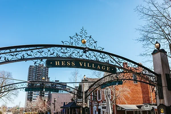 Hess Village entrance arch sign in downtown Hamilton, Ontario on a clear day