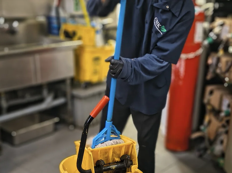 CSIK janitorial staff mopping the floor of a commercial facility